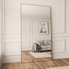 A large mirror reflecting natural light in a minimalist interior.